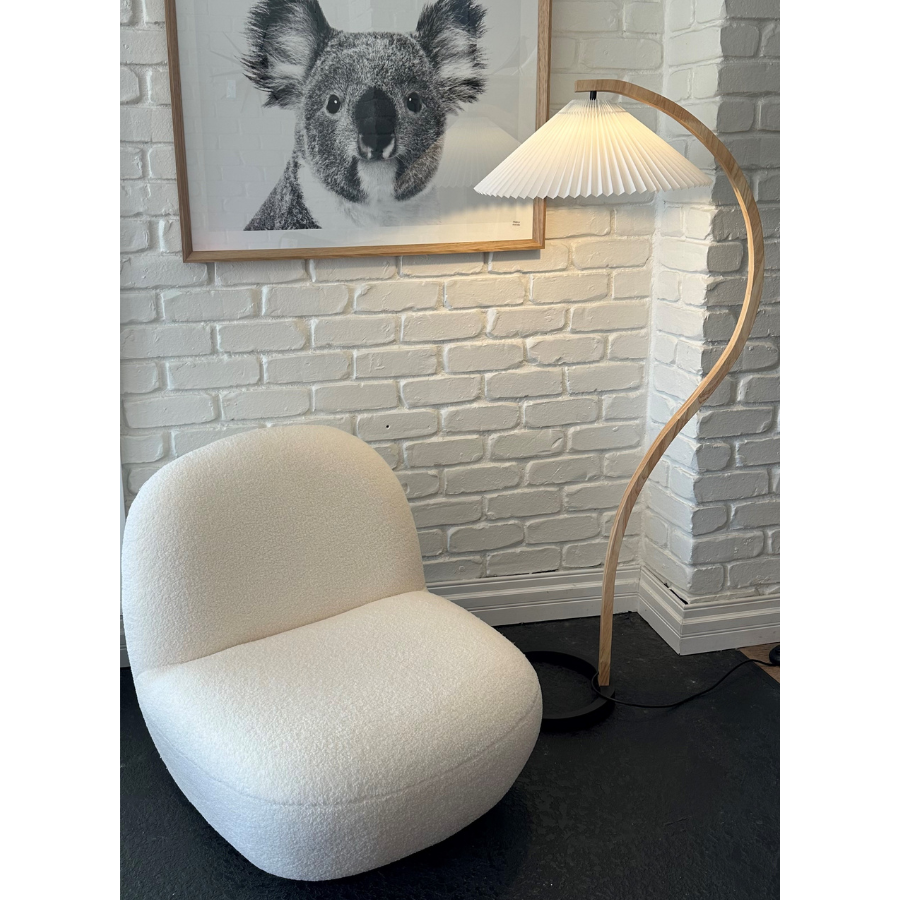 Styled image of the Pacha Lounge Chair - Replica Pierre Paulin - Boucle Fabric next to a Replica Floor Light.